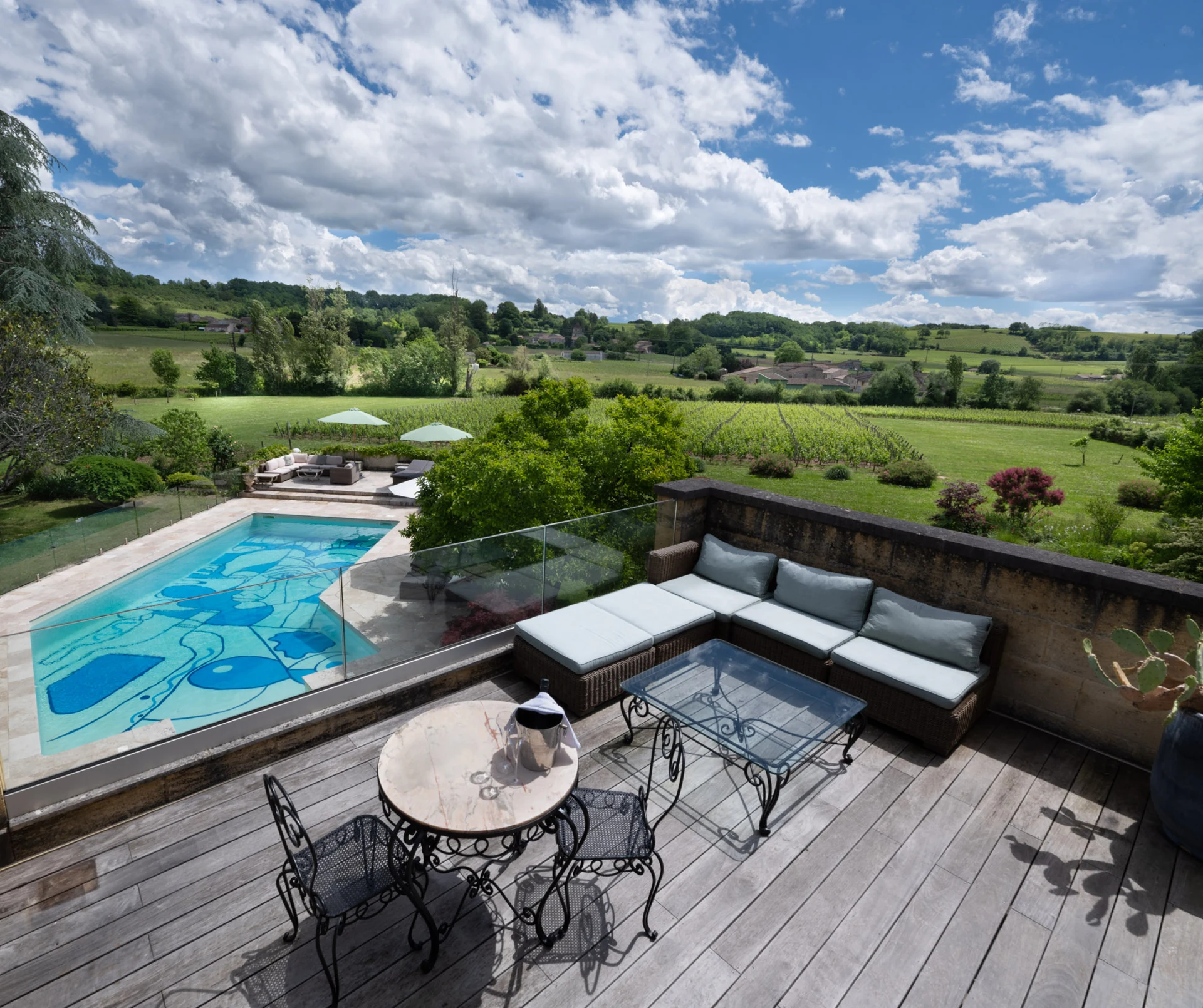 Vue depuis la terrasse du Palanquey sur la piscine et les vignobles de Saint-Émilion